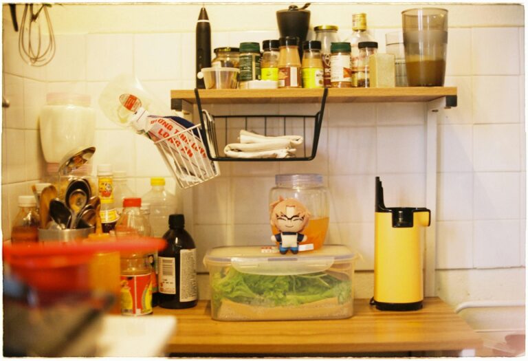 A small kitchen counter with spice rack, containers, and utensils for efficient storage.